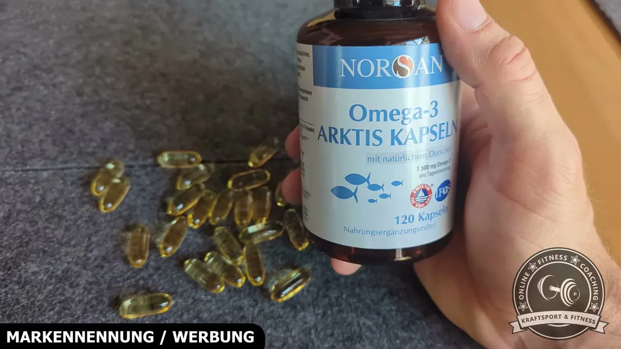Neben der Dose sind die einzelnen bernsteinfarbenen Dorschöl-Kapseln auf der Unterlage zu sehen.