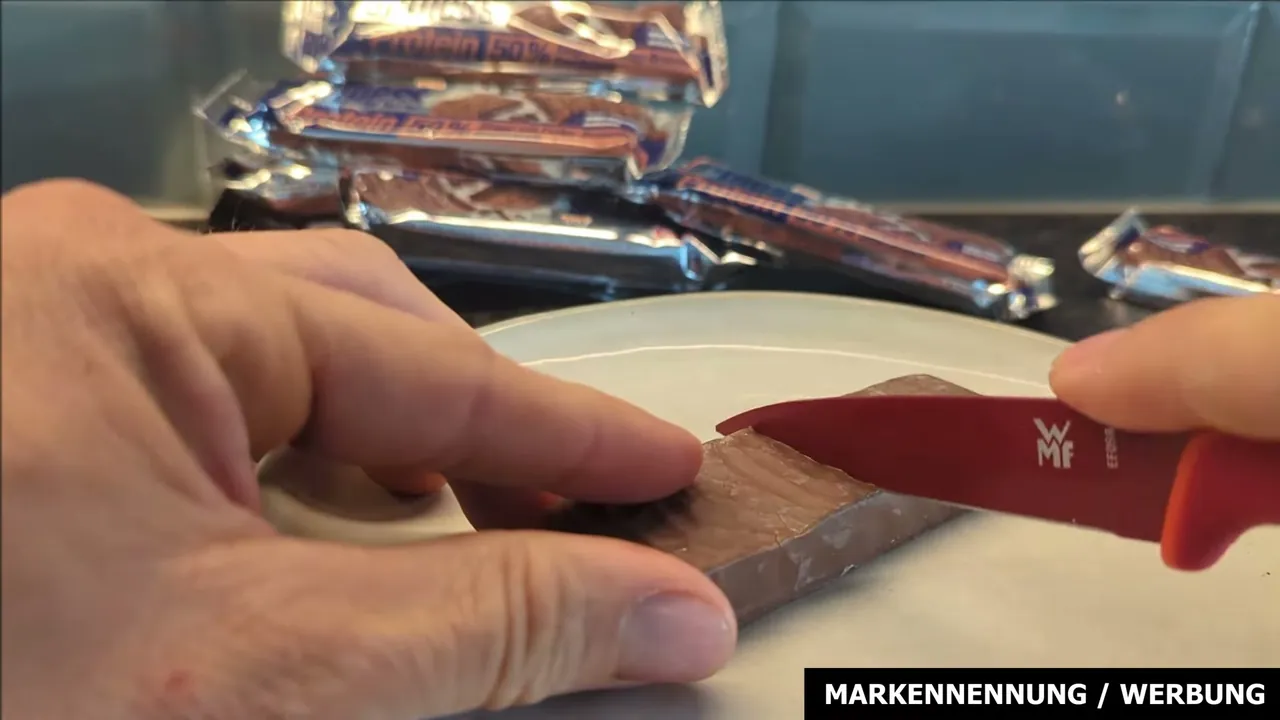 In meinem Test schneide ich den Riegel an – ich lege ihn vor dem Verzehr am liebsten für mehr Festigkeit kurz in den Kühlschrank.